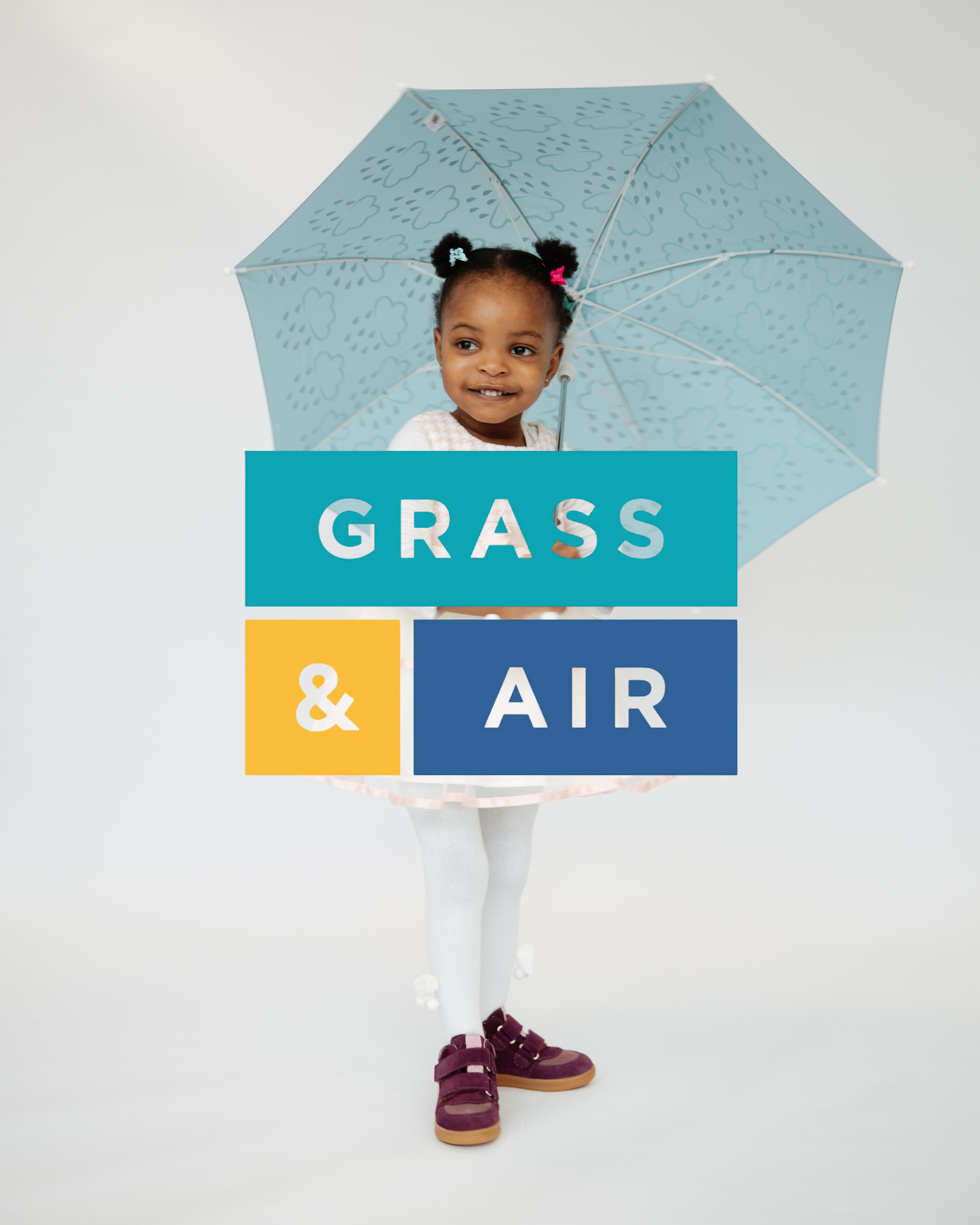 Young girl holding a light blue rain umbrella wearing burgundy Grass & Air children's shoes and white tights